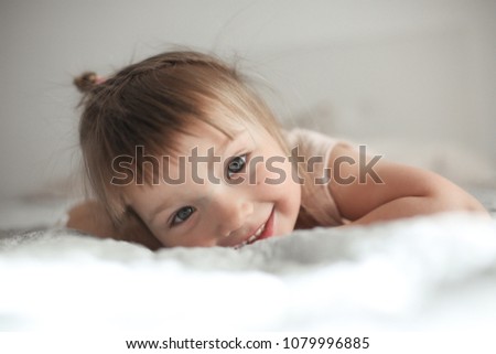 Similar – Little girl smiling lying over the bed