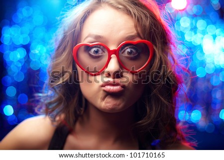 Funny girl wearing heart-shaped glasses at party