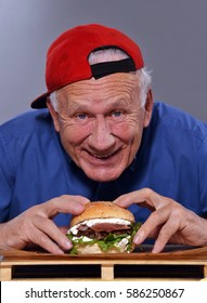 Funny Grandfather Eating Burger. Old Man Eat Burger.