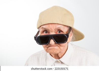 Funny grandma's studio portrait  wearing eyeglasses and baseball cap, isolated on white