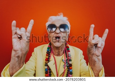 Funny grandmother portraits. Senior old woman dressing elegant for a special event. Rockstar granny on colored backgrounds