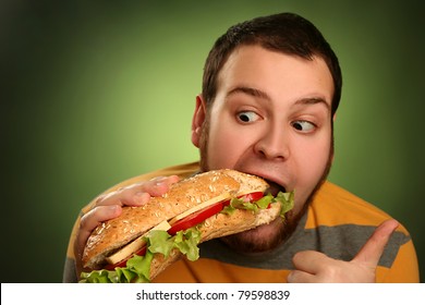 funny guy eating hamburger on green background