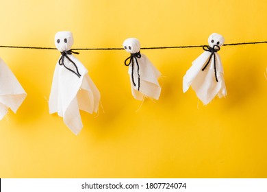 Funny Halloween Day Decoration Party, Full Body Of Baby Cute White Ghost Crafts Scary Face Hanging, Studio Shot Isolated On Yellow Background, Happy Holiday DIY Handicraft Concept