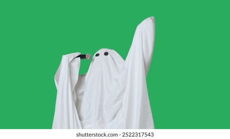 Funny halloween ghost in white sheet singing son in karaoke microphone, isolated on chroma key green screen background. Happy halloween spooky concept. - Powered by Shutterstock