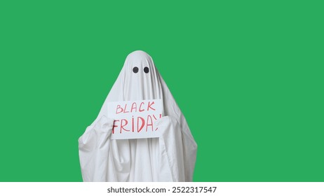 Funny halloween ghost in white sheet shows paper sign with word Black Friday, isolated on chroma key green screen background. Happy halloween spooky concept. - Powered by Shutterstock