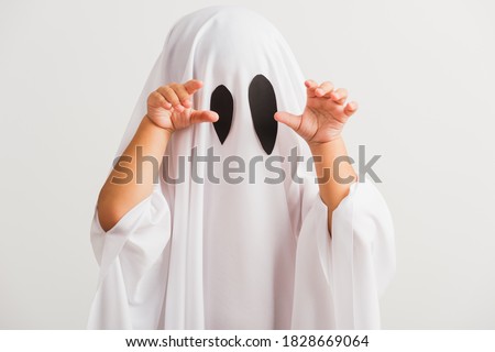 Funny Halloween Kid Concept, little cute child with white dressed costume halloween ghost scary, studio shot isolated on white background