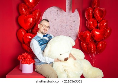 Funny happy bearded retro style man in the blue vest holding big teddy bear for Valentine day