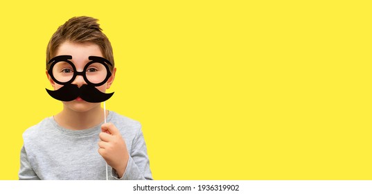 Funny happy boy with black hipster mustache and glasses, child pretends to be dad, professor or nerd on yellow banner background, Fathers Day, mens health, smart kids, joke, emotion, copy space. - Powered by Shutterstock