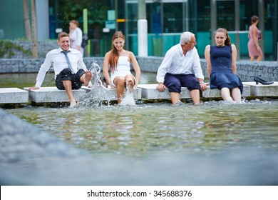 Funny Happy Business People Splashing Water With Their Feet In A Lake