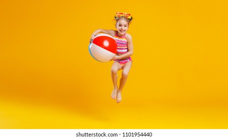  funny happy child   jumping in swimsuit and swimming glasses on colored background