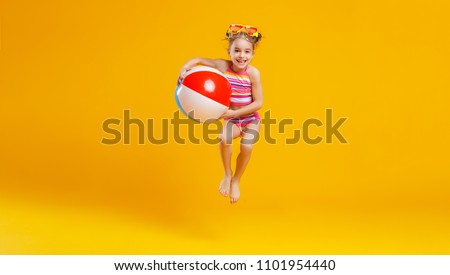  funny happy child   jumping in swimsuit and swimming glasses on colored background
