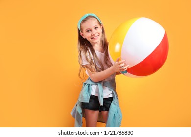 Funny Happy Child In Summer Holding Beachball On Yellow Background