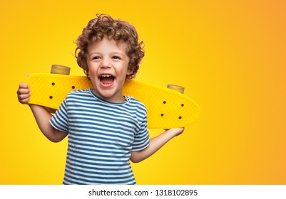 Funny happy kid in casual t-shirt holding longboard on shoulders looking super excited  - Powered by Shutterstock