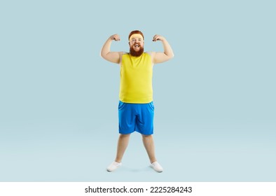 Funny happy positive cheerful excited motivated fat man in sweatband, yellow top and blue shorts smiling, flexing arms and showing his weak muscles. Sports exercise, fitness workout at the gym concept - Powered by Shutterstock