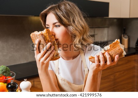 Funny Housewife in the kitchen smeling fresh bread
