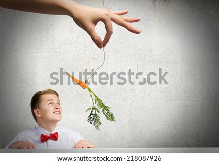 Funny image of businessman chased with carrot