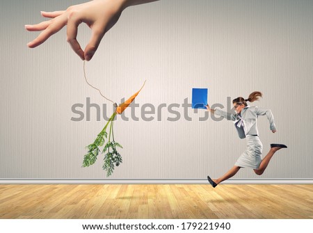 Funny image of businesswoman chased with carrot