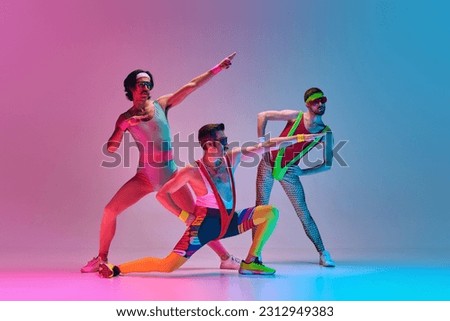 Funny image of three men in stylish, vintage sportswear training aerobics and gymnastics against gradient blue pink studio background. Concept of sportive and active lifestyle, humor, retro style. Ad