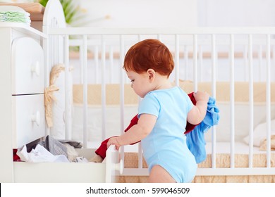 Funny Infant Baby Throwing Out Clothes From The Dresser At Home