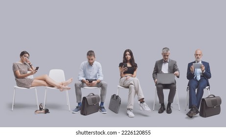 Funny job candidates in the waiting room, they are sitting on chairs and getting bored, employment and recruitment concept - Powered by Shutterstock