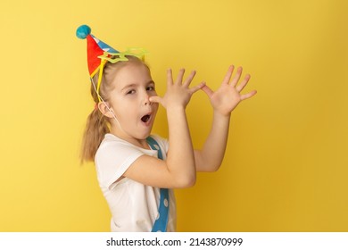 Funny Kid Clown Against Yellow Background. Happy Child Playing With Festive Decor. Birthday And 1 April Fool's Day Concept.