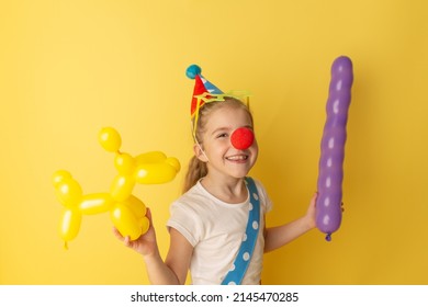 Funny Kid Clown Against Yellow Background. Happy Child Playing With Festive Decor. Birthday And 1 April Fool's Day Concept.