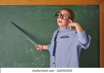 Funny Kid Girl With Teacher Costume In Green Blackboard With School Ruller