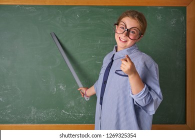 Funny Kid Girl With Teacher Costume In Green Blackboard With School Ruller