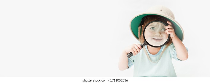 Funny kid girl wearing safari hat  with magnifying glass. Safari,zoo,Ecology and Earth day concept