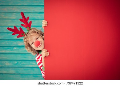 Funny Kid Holding Cardboard Banner Blank. Child Playing At Home. Christmas Holiday Concept. Copy Space.