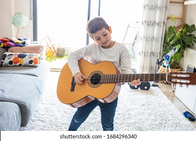 Funny Kid Playing Guitar At Home