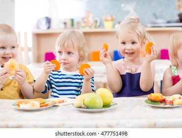funny kids eating fruits in kindergarten dinning room
