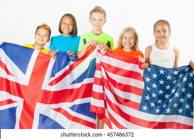 Funny kids holding flag of Great Britain and american national flag. Group of school children. Multiethnic students. Back to school. Friends. Fans, Rio. White background