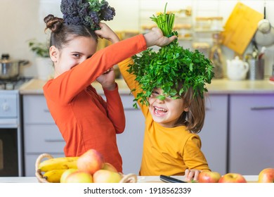 Funny kids make green smoothies while having fun. Happy sister and brother helping in the kitchen, laughing, opens the lid of the blender. Fun vegan family cooking activities. Healthy Eating Concept