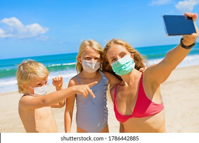 Funny Kids With Mother Taking Selfie Photo By Smartphone On Tropical Sea Beach. Rule To Wear Face Covering Mask At Public Places Due Coronavirus COVID 19. Family Holidays With Children, Summer Travel.