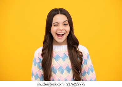 Funny Kids Winks Face. Portrait Of Funny Teenager Child Girl Smiling And Winkind Making Funny Faces. Studio Close Up Portrait Crazy And Fun On Yellow Background.