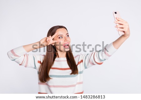 Funny lady making selfie showing v-sign symbol wear striped pullover isolated white background