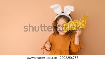 A funny laughing child in the guise of a rabbit closes his eye with the numbers 2023. The year according to the zodiac sign of the Eastern calendar. Christmas Greeting poster