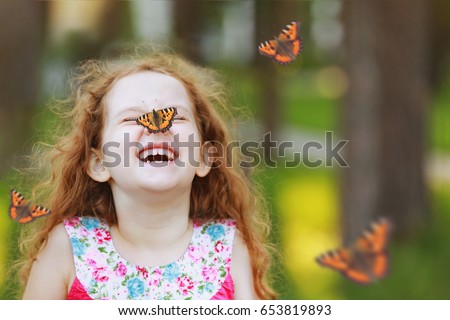 Funny laughing curly girl with a butterfly on his nose. Healthy smile with white teeth. Free breathing concept.