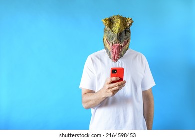 Funny Laughing Dinosaur Head On Human Body On White T-shirt On Blue Background, Looking At His Smart Phone, Clip Art, Negative Space.