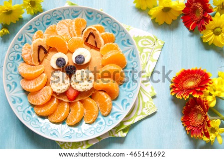 Funny lion pancake with mandarins and berries