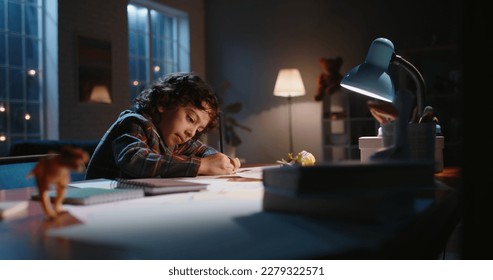 Funny little asian kid drawing at home  Boy and curly hair drawing and pencils paper in the evening  learning art  having fun at home    hobby concept 