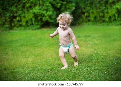 Funny Little Baby Wearing A Diaper Running In The Garden On A Hot Summer Day