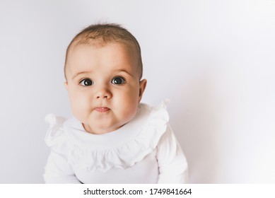 Funny little baby wearing a diaper playing on a white knitted blanket in a sunny nursery. Child after bath or shower on a fresh towel. Infant nappy change and skin care. Cute kid playing with his feet