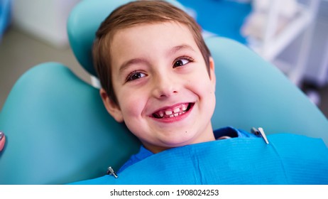 Funny Little Boy Smiles In A Dental Clinic. Work Of A Dentist With Children. Healthcare And Medicine Concept.