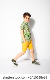 funny little boy walking and smiling to camera on white background - Shutterstock ID 1410338666