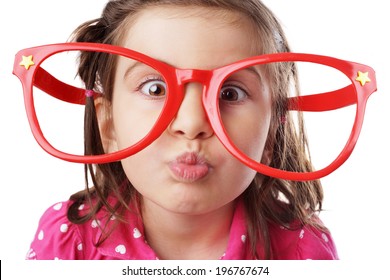 Funny little girl with big red glasses making face