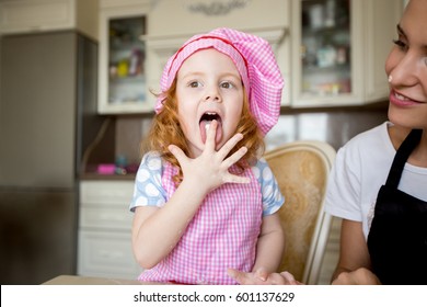 Funny Little Girl In Chefs Hat Licking Fingers