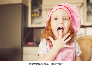 Funny Little Girl In Chefs Hat Licking Fingers