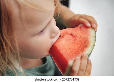 Funny Little Girl Eating Watermelon Close-up. Cute Child With Watermelon Indoors. Concept Of Healthy Food, Summertime. Copy Space